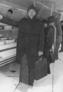 ARH Slg. Bartling 1609, Oberkreisdirektor Hans Meier im Lodenmantel mit Wollmütze auf dem Kopf und Tasche an der Linken beim Einkauf an einem Stand auf dem Wochenmarkt, Neustadt am Rübenberge, um 1970