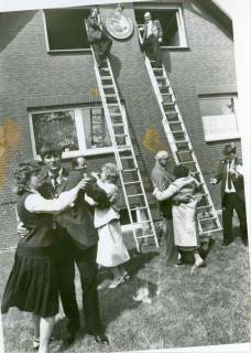 ARH Slg. Bartling 162, Annageln der Königsscheibe an die Giebelwand des Wohnhauses durch zwei Männer auf Leitern, auf dem Rasen davor der Schützenkönig N. N. beim Tanz, Stöckendrebber, um 1989