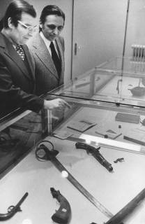 ARH Slg. Bartling 1695, Kreisdirektor Wolfgang Kunze (l.) und ... Löhr (?) betrachten die alten Waffen in einer Ausstellungsvitrine, Neustadt a. Rbge., 1975