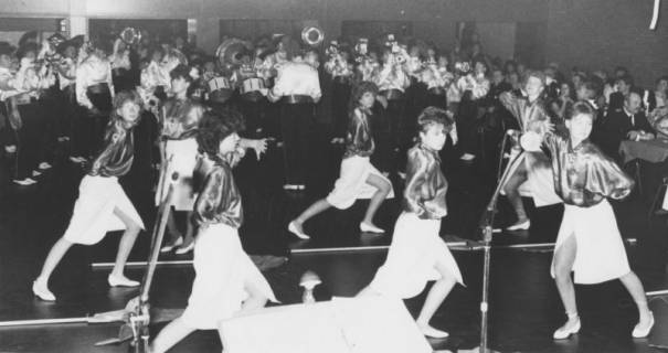 ARH Slg. Bartling 1771, Damen-Show-Tanzgruppe bei einer Vorführung im Saal des Freizeitzentrums, im Hintergrund das Trompeter-Showcorps Leinegarde (3 Ex.), Neustadt a. Rbge., um 1975