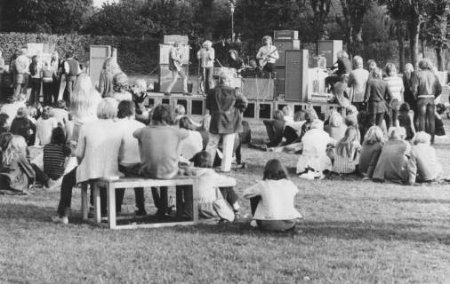 ARH Slg. Bartling 1802, Auftritt einer fünfköpfigen Band mit zwei Gitarren, Schlagzeug und Keyboard auf dem Gelände des Freibades, im Vordergrund die Zuhörenden auf dem Rasen und auf Bänken sitzend, Neustadt a. Rbge., 1971