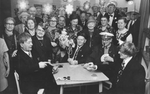ARH Slg. Bartling 1887, Gruppe von karnevalistisch verkleideten Senioren und Seniorinnen um einen Tisch mit Skatspielern im Altenclub Schleuß, Neustadt a. Rbge., 1974