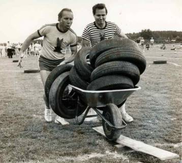 ARH Slg. Bartling 1891, Spiel ohne Grenzen, zwei Männer bei der Beförderung von Autoreifen über ein Wippbrett, Bordenau, 1987