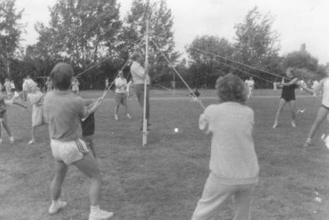 ARH Slg. Bartling 1895, Jugendliche Sportler ziehen an Seilen eine mittig aufgestellte Stange, die von einem Mann gehalten wird, Neustadt a. Rbge., um 1975