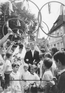 ARH Slg. Bartling 1911, Brautpaar Dorle und Eckhard Jordan (Sportler) schreitet nach der Trauung durch ein Spalier von jungen Menschen mit erhobenen Reifen, Neustadt a. Rbge., 1969