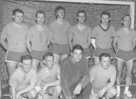 ARH Slg. Bartling 1955, Gruppenporträt der 10-köpfigen Handballmannschaft vor einem Tor, anläßlich der Erringung eines Wanderpokals (?), Neustadt am Rübenberge, um 1975