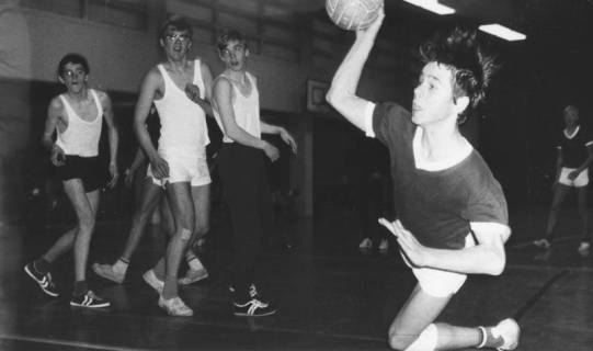 ARH Slg. Bartling 1963, Jugend-Handballer in der TSV-Sporthalle beim Fallwurf auf das Tor, links im Hintergrund drei beobachtende Mitspieler, Blick von der Torlinie, Neustadt a. Rbge., 1969