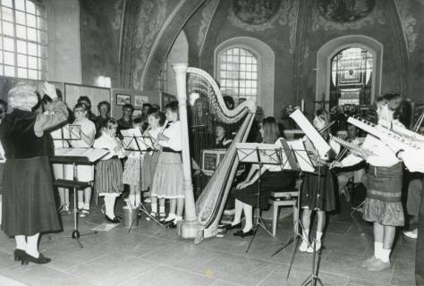 ARH Slg. Bartling 2160, Dora Kolesch (l.) beim Dirigat eines Jugendorchesters u. a. mit Blockflöten und Harfe im Altarraum der Kirche, Blick in die Apsis, Basse, um 1980