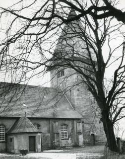 ARH Slg. Bartling 2164, Simon- und Judas-Kirche, Blick von Nordosten durch den entlaubten Baum auf den Turm und das Langhaus mit Eingang, Basse, 1974