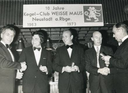 ARH Slg. Bartling 2219, Gruppe von fünf Männern in festlicher Kleidung, darüber hängend ein Schild mit der Aufschrift "10 Jahre Kegel-Club Weisse Maus Neustadt a. Rbge. 1963-1973", Neustadt a. Rbge., 1973