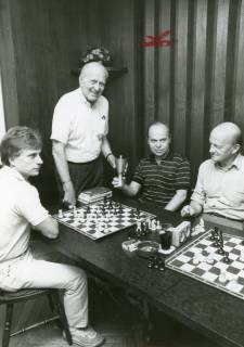ARH Slg. Bartling 2279, Schachpartie (mit Schachuhr) zwischen Karlheinz Heider (r.) und N. N. unter den Augen von zwei weiteren Männern, Neustadt a. Rbge., um 1973