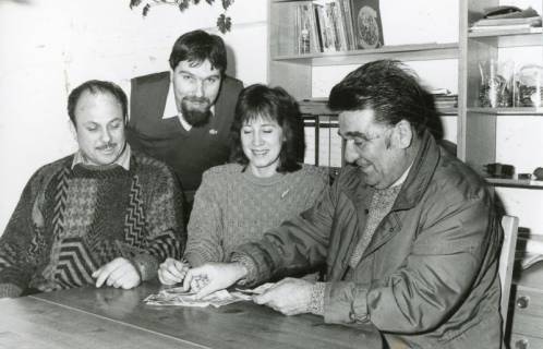 ARH Slg. Bartling 2308, Drei Männer und eine Frau am Tisch sitzend beim Geldzählen, Neustadt a. Rbge., um 1970