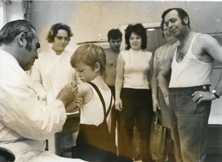 ARH Slg. Bartling 2324, Leiter des Gesundheitsamtes Dr. Simon Kaindl (l.) sitzend und einem Kindergartenkind die Pockenimpfung verabreichend, Neustadt a. Rbge., 1972