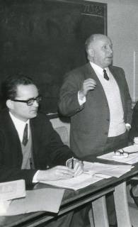 ARH Slg. Bartling 2350, DRK-Kreisgeschäftsführer Christian von Winkler hinter einem Tisch vor einer Tafel stehend und dozierend, daneben sitzend N. N., Neustadt a. Rbge., 1969