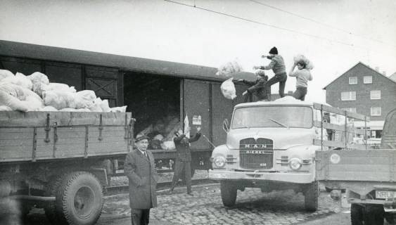 ARH Slg. Bartling 2393, Jugendliche Helfer des DRK beim Verladen der gesammelten Altkleider vom LKW in den Güterwaggon am Bahnhof, Neustadt a. Rbge., um 1973