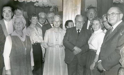 ARH Slg. Bartling 2431, Gruppe von festlich gekleideten Männern und Frauen stehend, darunter Heinrich Harmening (Mitte), der Vorsitzende des Reichsbundes, Neustadt a. Rbge., um 1975