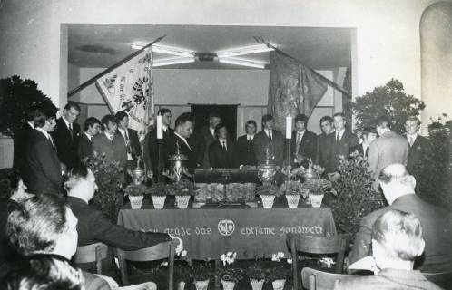 ARH Slg. Bartling 2466, Freisprechung der Lehrlinge, die hinter einem Tisch stehen, auf dem neben Blumen die Lade und die Pokale postiert sind, Neustadt a. Rbge., um 1970