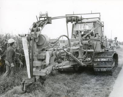 ARH Slg. Bartling 2502, Verlegung von HASTRA-Elektro-Kabel samt Trassenwarnband mithilfe eines Kabelpflugs (Kettenfahrzeug), Schrägansicht von vorn, Neustadt a. Rbge., um 1975