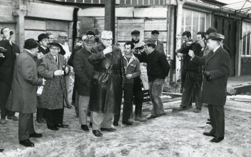 ARH Slg. Bartling 2546, Bürgermeister und Bauunternehmer Wilhelm Rahlfs (Mitte) mit zahlreichen anderen Männern beim Umtrunk vor einem entkernten Bau, Neustadt a. Rbge., 1969