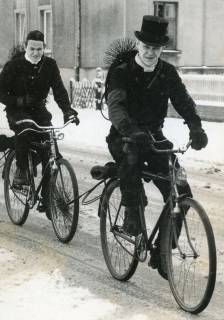 ARH Slg. Bartling 2566, Schornsteinfeger Kaufung (l.) und Kastenschmid in Arbeitskleidung Fahrrad fahrend auf schneebedeckter Straße, Neustadt a. Rbge., 1970