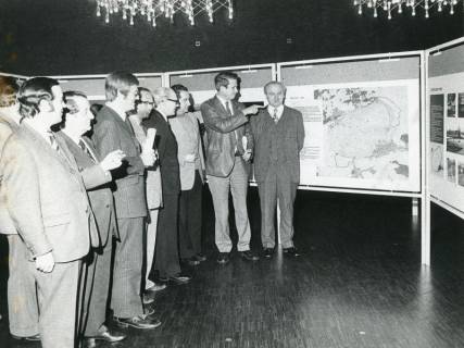 ARH Slg. Bartling 2627, Ausstellung im Bürgersaal des FZZ, Stadtdirektor Felix Rohde (2. v. r.) erläutert den Gästen die Exponate auf den Ausstellungstafeln, Neustadt a. Rbge., 1974
