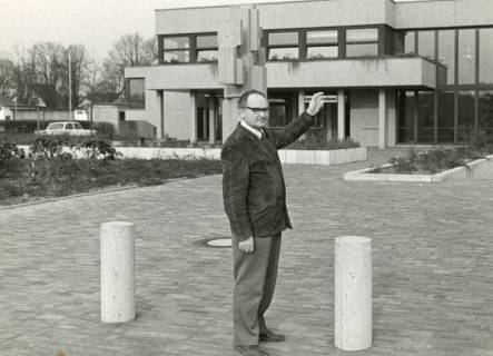 ARH Slg. Bartling 2640, Bürgermeister Herbert Gubba auf dem Platz vor dem Eingang zur Leinepark-Klause stehend und mit ausgestrecktem Arm auf das FZZ-Gebäude weisend, Neustadt a. Rbge., um 1975