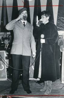 ARH Slg. Bartling 2661, Zeltfest mit Feuerwehrkapelle Dudensen (?), auf der Bühne ein Soldat in Uniform (l.) und die Moderatorin im langen Mantel mit Mikrofon, Dudensen, um 1975