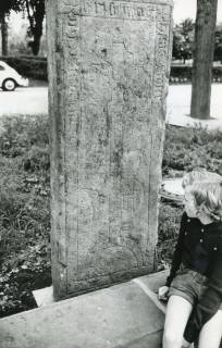 ARH Slg. Bartling 2672, Mittelalterliche Grabplatte des Hans Stoter, mit eingeritztem lateinischem Kreuz über einem Halbkreisbogen [begleitet von Haken und Beil] und Umschrift (ca. 1300), am FZZ, Neustadt a. Rbge., 1972
