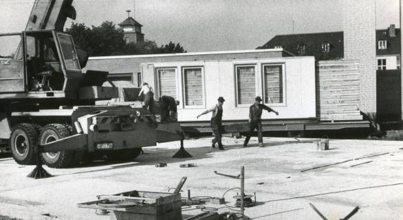 ARH Slg. Bartling 2679, Errichtung einer vorübergehenden Geschäftsstelle der Kreissparkasse, im Hintergrund der Feuerwehrturm und das Dach der Realschule, Neustadt a. Rbge., 1970