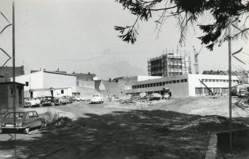 ARH Slg. Bartling 2698, Neubau der Kreissparkasse an der Marktstraße, Blick über den zukünftigen Parkplatz auf den im Rohbau fertigen Gebäudekomplex samt dem eingerüsteten Turm von Südwesten, rechts ein Baukran, Neustadt a. Rbge., 1972