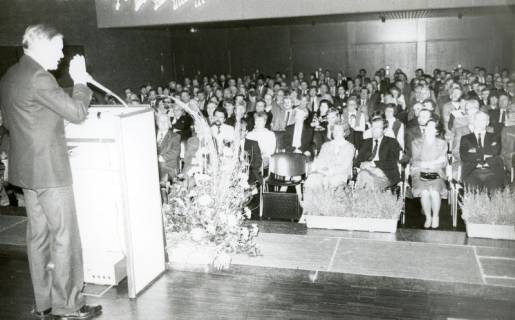 ARH Slg. Bartling 2713, Festveranstaltung im FZZ, Blick von der Bühne auf die zuhörenden Gäste im vollbesetzten Bürgersaal, links der Redner am Pult, Neustadt a. Rbge. (2 Ex.), um 1975