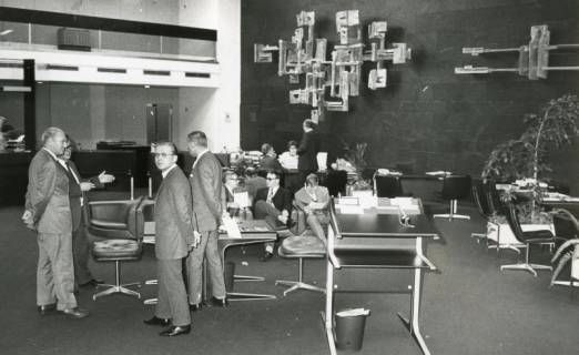 ARH Slg. Bartling 2725, Szene in der Besucherhalle einer Sparkasse, an der schwarz verkleideten Wand zwei große abstrakte Skulpturen, links eine auslaufende Galerie, Neustadt a. Rbge., 1970