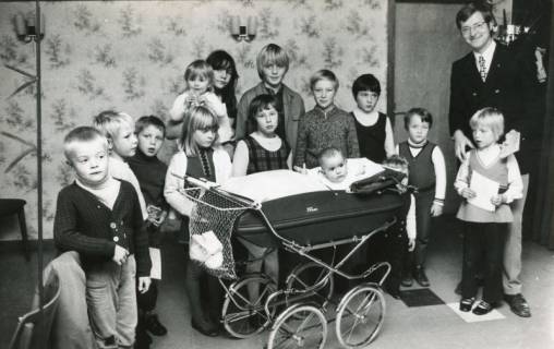 ARH Slg. Bartling 2726, Werbeleiter Rolf Hantelmann mit zahlreichen Kindern einschl. Kinderwagen in der Kinderecke der neuen Kreissparkasse, Neustadt a. Rbge., 1973