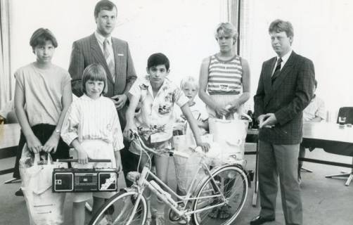 ARH Slg. Bartling 2799, Fünf Kinder bzw. Jugendliche mit gewonnenen Preisen (Fahrrad, Kofferradio u. a.) begleitet von den Sparkassenangestellten Rainer Weihrauch (l.) und Ernst Hahne (r.), Neustadt a. Rbge., um 1975