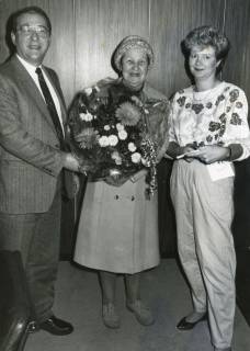 ARH Slg. Bartling 2832, Direktor der Volksbank Neustadt Eggers gratuliert mit einem Blumenstrauß einer älteren Dame, rechts Kauffrau Marion Krenz, Neustadt a. Rbge., um 1973