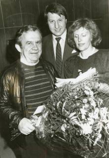 ARH Slg. Bartling 2834, Ein Vertreter der Volksbank Neustadt (Mitte) und Monika Zettlitz als Vertreterin der GFW gratulieren einem älteren Mann mit einem Blumenstrauß, Neustadt a. Rbge., um 1973