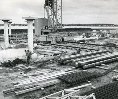 ARH Slg. Bartling 2871, Errichtung der Kooperativen Gesamtschule (KGS), Blick auf die Baustelle unterhalb des Baukrans, am Boden das Bauholz, die Stahlmatten u. a. m., Neustadt a. Rbge., 1972