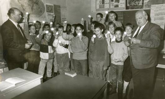 ARH Slg. Bartling 2893, Gruppenfoto einer Grundschulklasse der Goethe-Schule mit Lehrer N. N. (l.) und Bürgermeister Henry Hahn (r.), alle mit einem beleuchteten Stern in der erhobenen Hand, Neustadt a. Rbge., um 1974