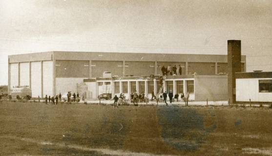 ARH Slg. Bartling 3015, Schule Am Ahnsförth, Gutachterbegehung des Daches nach einem Brand des Gebäudeteils neben der Sporthalle, Ansicht von vorn, Neustadt a. Rbge., um 1975