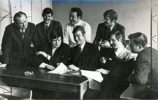 ARH Slg. Bartling 3047, Kreisberufsschule, Gruppe von sieben jungen Männern mit Lehrer an einem Tisch sitzend bzw. stehend beim Studium von Schriftstücken, Neustadt a. Rbge., 1970