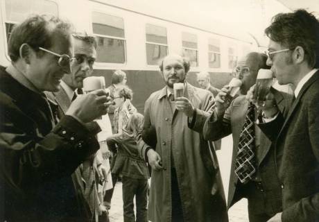 ARH Slg. Bartling 3104, Einweihung der Eisenbahn-Unterführung und des Zentralen Omnibusbahnhofs: Umtrunk einer Gruppe von fünf städtischen Angestellten vor einem D-Zug-Wagen am Bahnsteig, Neustadt a. Rbge., 1975