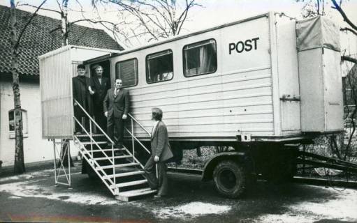ARH Slg. Bartling 3185, Mobile Poststation des Postamtes auf Anhänger, auf der Zugangstreppe vier Männer stehend, Neustadt a. Rbge., 1973