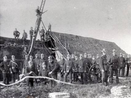 ARH Slg. Bartling 3289, Repro: Erstes Gruppenfoto der Freiwilligen Feuerwehr mit Gerätschaften vor einer Scheune mit großem Dach, Neustadt a. Rbge., um 1900