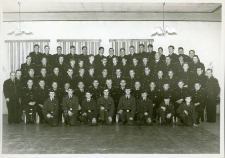 ARH Slg. Bartling 3300, Gruppenbild der Mitglieder der Freiwilligen Feuerwehr in Uniform (ohne Mütze) aufgestellt in einem Saal, Ansicht von vorn, Neustadt a. Rbge., 1968