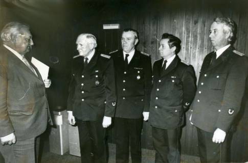 ARH Slg. Bartling 3318, Ehrung von vier nebeneinander stehenden Feuerwehrleuten durch Bürgermeister Henry Hahn (l.), Neustadt am Rbge., um 1975