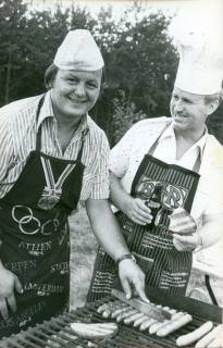 ARH Slg. Bartling 3376, Zwei Polizisten in Zivil mit Schiffchen bzw. Kochmütze beim Grillen von Würstchen im Freien, Neustadt a. Rbge., 1973