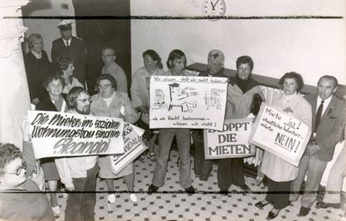 ARH Slg. Bartling 3389, Im Eingangsbereich des Neustädter Amtsgerichts demonstrieren einige Männer und Frauen mit Plakaten gegen "staatliche Wuchermiete", Neustadt a. Rbge., 1974