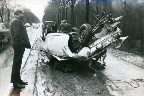 ARH Slg. Bartling 3395, Auf der B 6 verunglückte, auf dem Dach liegende, völlig zerstörte Limousine, links ein nachdenklicher Betrachter, Blick auf das Wrack zwischen Fahrbahn und Fahrradweg, 1970