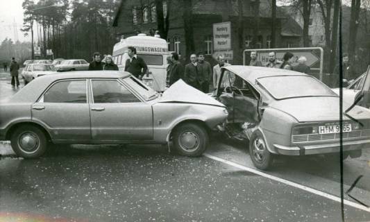 ARH Slg. Bartling 3404, Zwei PKW's (Skoda und Opel) nach einem Zusammenprall an der Einmündung der Bordenauer Straße in die B 6, im Hintergrund ein Rettungswagen und die Gaststätte Am Dammkrug, Neustadt a. Rbge., 1974
