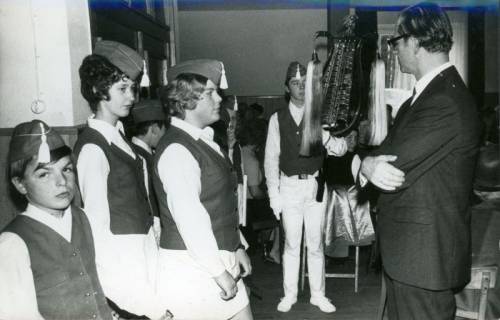 ARH Slg. Bartling 3452, Superintendent Thomas mit verschränkten Armen stehend vor einer Gruppe von Mitgliedern eines Spielmannszuges, Neustadt a. Rbge., 1971